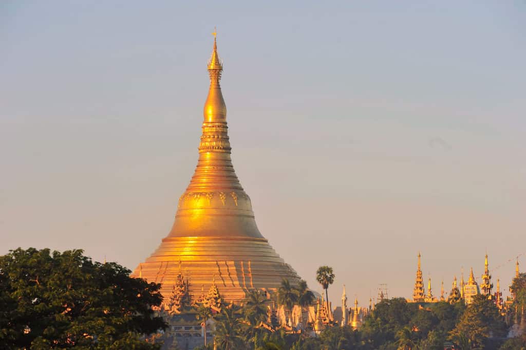 Shwedagon pagoda temple with village below in the morning light at yangon, myanmar